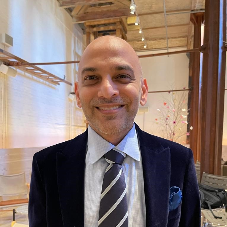 Photo of Kevin Coutinho in a large exhibition space with wooden pillars in the background