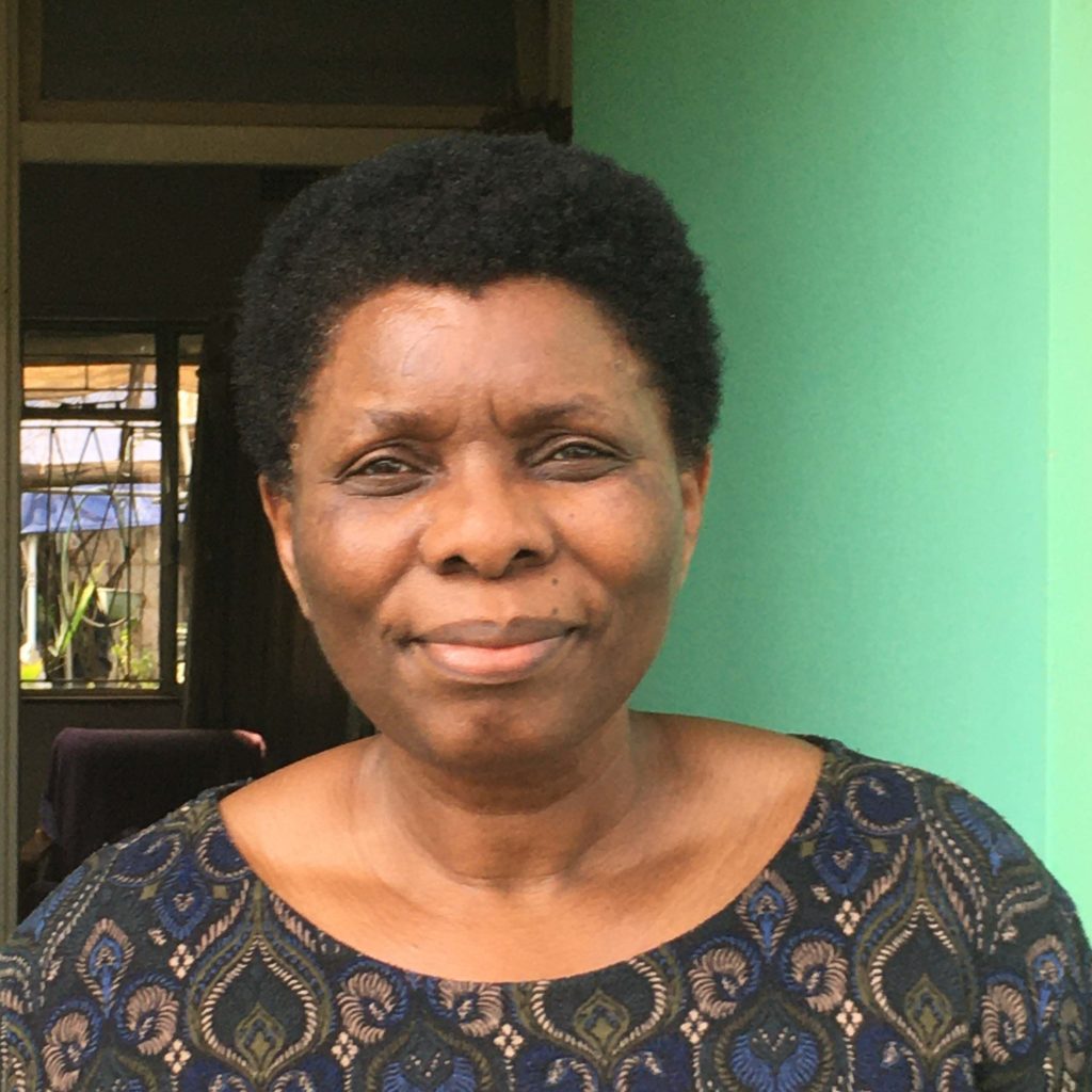 Photo of Opha Pauline Dube in front of a green wall