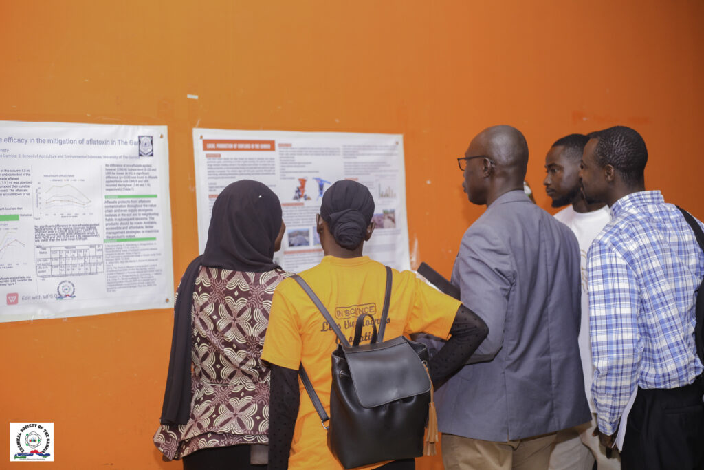 Gambian researchers discussing a scientific poster